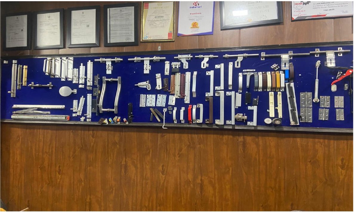 Wall-mounted hardware sample board — hinges, handles, rollers and fittings